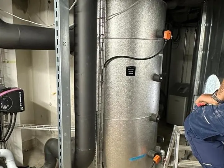 Ballon tampon isolé de grande capacité dans un local technique, pompe de circulation et échelle